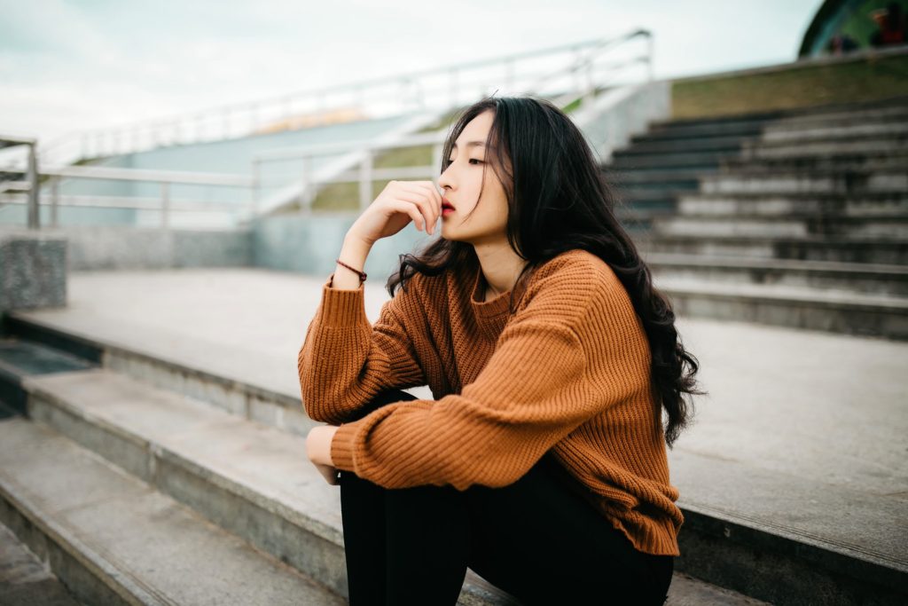 woman-brown-sweater-sitting-thinking-contemplating